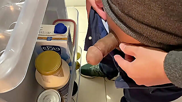 Hot Asian friend gives handjob while teasing guy's cock near fridge